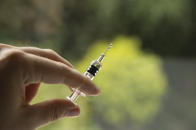 Une main prise en photo avec un vaccin.